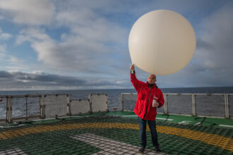 Juergen Graeser launches a weather balloon on the helicopter deck of Polarstern research vessel in 2019. Credit: Esther Horvath