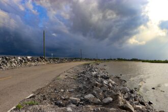 Island Road, the only road to Isle De Jean Charles, is often flooded by encroaching water leaving residents stranded on the island for hours or days at a time. Credit: Katie Livingstone/Inside Climate News