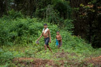 Arara indigenous children walk at the Arado tribal camp, in Arara indigenous land in Para state, Brazil on March 13, 2019. Credit: Mauro Pimentel/AFP via Getty Images