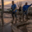 Residents work to push back wet mud that trapped cars and invaded some houses on Jan. 11, 2023 in Piru, east of Fillmore, California. A series of powerful storms pounded California in striking contrast to the past three years of severe to extreme drought experienced by most of the state. Credit: David McNew/Getty Images