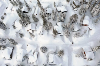 In Mammoth Lakes, California, snow covers roofs next to snowbanks in March piled up from new and past storms in the Sierra Nevada mountains, in the wake of an atmospheric river event. Credit: Mario Tama/Getty Images.