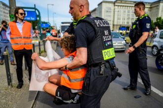 A police officer removes a demonstrator during a march by climate activists of the "Letzte Generation" (Last Generation) group as they walk down Karl-Marx-Allee boulevard on their way to the Chancellery in Berlin on May 31, 2023. Credit: John Macdougall/AFP via Getty Images