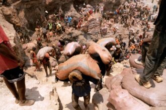 Artisanal miners carry sacks of ore at the Shabara artisanal mine near Kolwezi on October 12, 2022. Credit: Junior Kannah/AFP via Getty Images