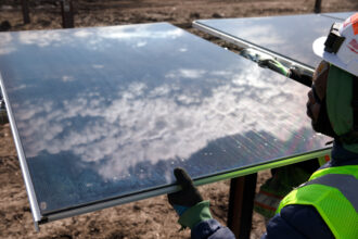 Workers install solar panels at the Double Black Diamond solar farm near Springfield, a 593-megawatt project that will produce clean energy for the city of Chicago. Credit: Rich Saal/Provided.