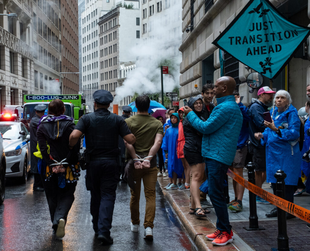 NYPD officers arrest climate protesters who blocked the entrance to the Federal Reserve Bank of New York Monday. Credit: Keerti Gopal