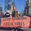 A protester wearing a mask holds an anti-fossil fuels banner during the demonstration outside the Bank of England. Credit: Vuk Valcic/SOPA Images/LightRocket via Getty Images