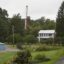 A car drives by a home with a nearby derrick drilling for natural gas near Calvert, Pennsylvania. Credit: Robert Nickelsberg/Getty Images