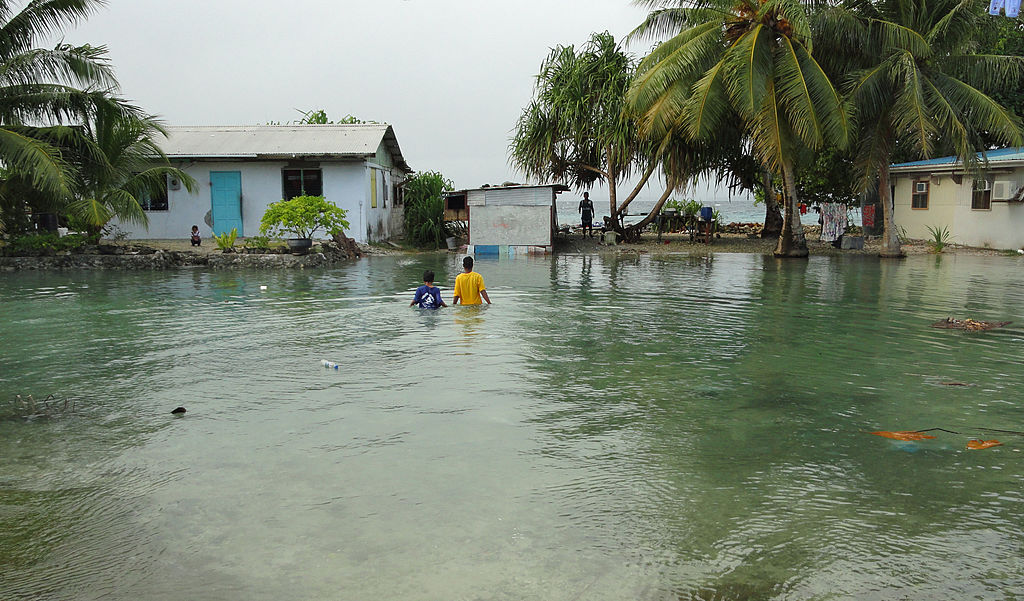 Local residents wade through flooding caused by high ocean tides in Majuro Atoll, the capital of the Marshall Islands, on February 20, 2011, with a warning of worse to come because of rising sea levels.