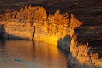 Lake Powell at sunrise on September 2, 2022 near Page, Arizona. The light colored "bathtub ring" above the waterline was created underwater before record drought reduced the flow of the Colorado River.