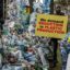 A climate activist holds a banner next to a plastic installation after marching to demand drastic reduction in global plastic production during the Break Free From Plastic Movement March ahead of the third meeting of the Intergovernmental Negotiating Committee (INC-3) in Nairobi on November 11, 2023.