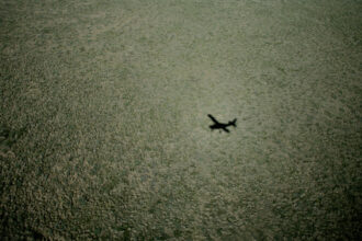 The shadow of a bush plane falls on the landscape of the National Petroleum Reserve in Alaska. The reserve includes the proposed Willow project. Credit: Andrew Lichtenstein/Corbis via Getty Images