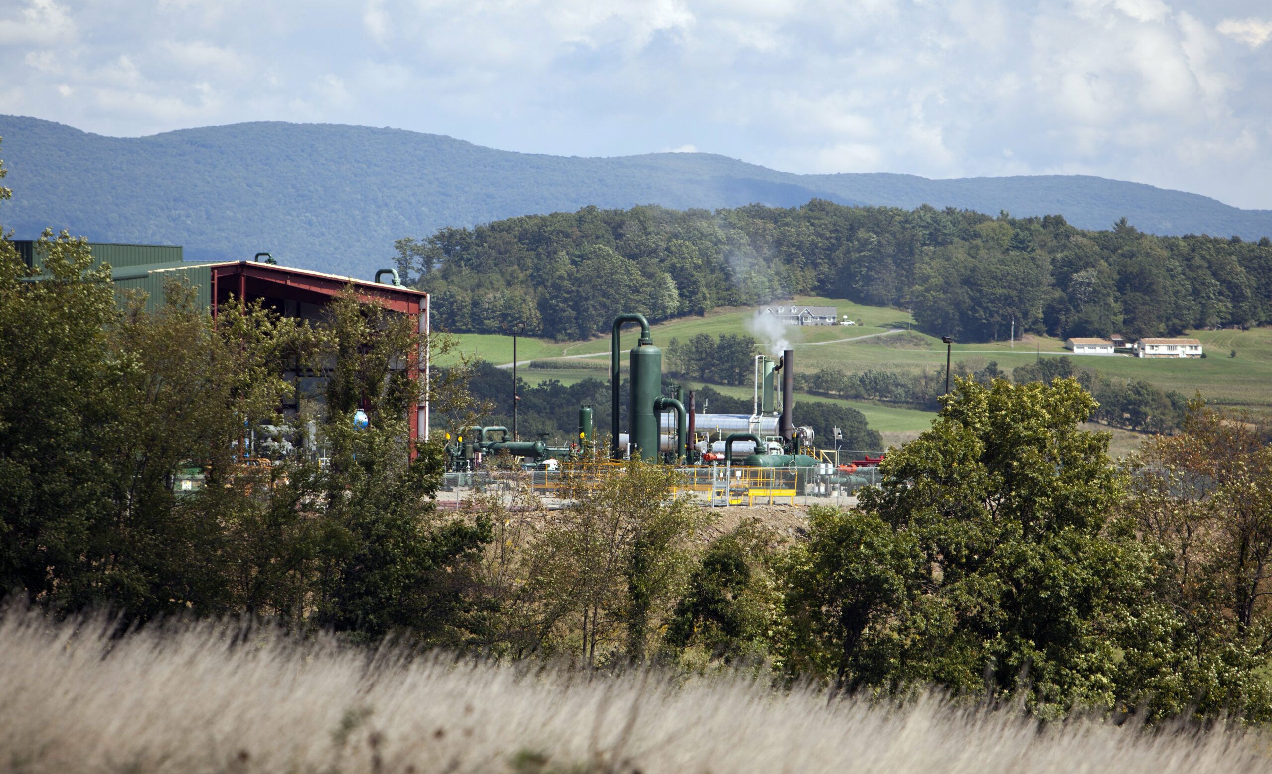 A natural gas compressor station on a hillside Septem in Penn Township, Pennsylvania. The area is situated above the Marcellus Shale, where a process called hydraulic fracturing, or fracking, pumps millions of gallons of water, sand and chemicals into horizontally drilled wells to stimulate the release of the gas. Credit: Robert Nickelsberg/Getty Images.