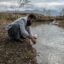 An Afghan scientist gathers water and soil samples at a water outflow from Bagram Airfield, formerly America's largest military base in Afghanistan. Credit: Kern Hendricks