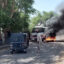 Sudanese security forces intervene in October 2021 as smoke billows from tyres set on fire by Sudanese students in the city of Nyala, the capital of South Darfur, demonstrating against the hikes in bread prices due to low wheat supply following the closure of Sudans' Red Sea port of Port Sudan. Credit: Abdelmonim Madibu/AFP via Getty Images.