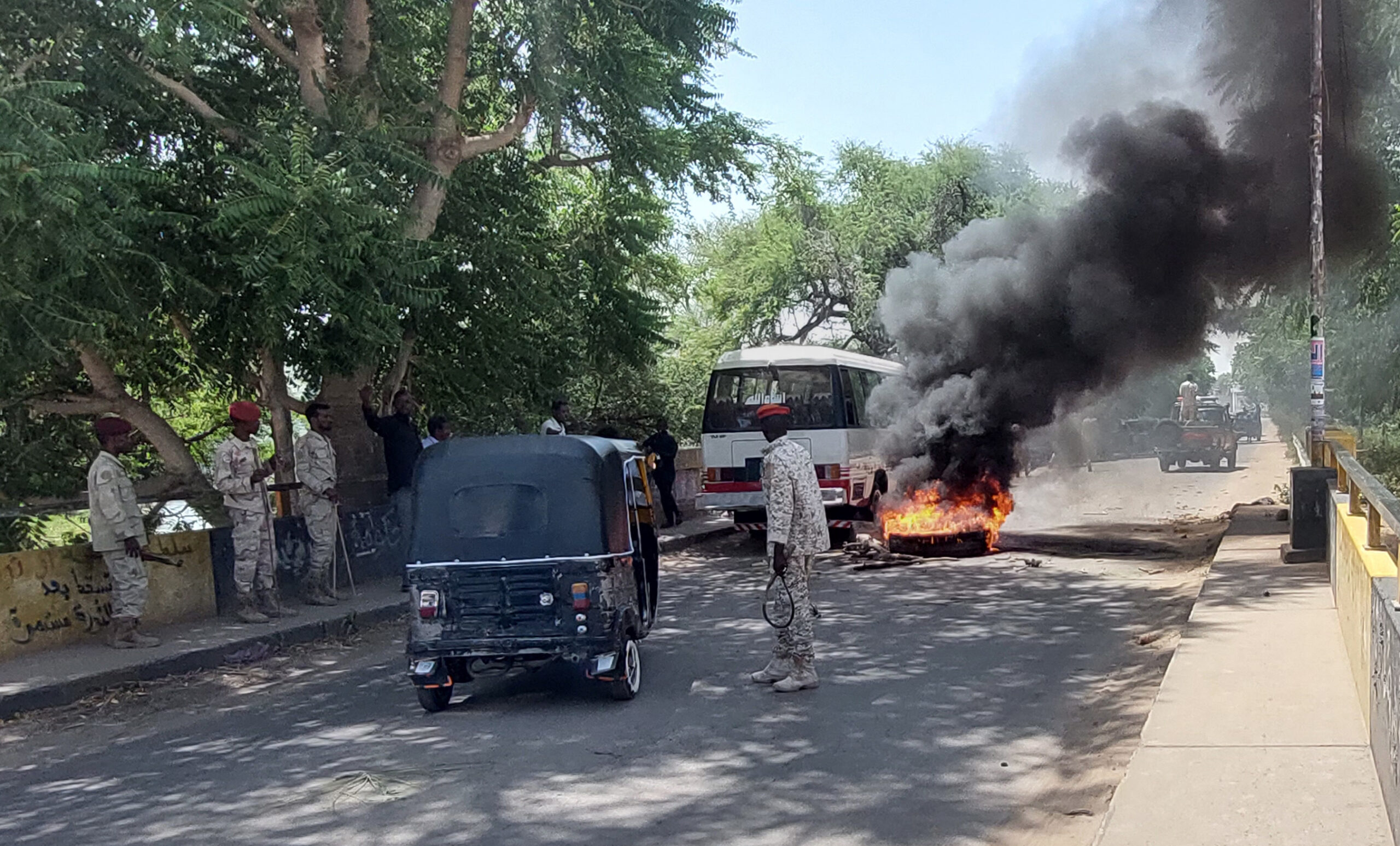 Sudanese security forces intervene in October 2021 as smoke billows from tyres set on fire by Sudanese students in the city of Nyala, the capital of South Darfur, demonstrating against the hikes in bread prices due to low wheat supply following the closure of Sudans' Red Sea port of Port Sudan. Credit: Abdelmonim Madibu/AFP via Getty Images.