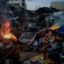 A resident sits in front of his destroyed house as another makes a fire in a devastated area in the aftermath of Typhoon Haiyan on Nov. 17, 2013 in Tacloban, Philippines. Credit: Kevin Frayer/Getty Images